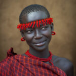 The Bodi (or Meen) tribe lives close to the Omo River in southern Ethiopia (Omo Valley) and has the Mursi tribe as south neighbor and Konso at north; It is a pastoral and agricultural tribe, thus livestock plays a large role in the tribe; Along the banks of the river, they cultivate sorghum, maize and coffee;
For their new year in June, called Kael, Bodi men consume large amounts of blood and milk to become overweight; This tradition measures the body fat of a contestant; Each family or clan is allowed to present an unmarried contestant; The winner of this contest is awarded great fame by the tribe; The women in the tribe wear goatskin skirts and have a plug inserted into their chin; Most of them are now Christians;
In Hana Mursi, the main town of the Bodis, the government plans to settle 300 000 people from all over Ethiopia over the next few years; Along with the workers and soldiers, AIDS and Hepatitis B are coming too; The Bodi tribespeople do not want to give up their traditions and their land to allow the new sugar cane plantations irrigated by the water of Gibe 3 dam, and live in the settlements planned by the government; If the Konso tribe attempts to set foot on their land with the support of the government, clashes will erupt as the Bodi elders predict;